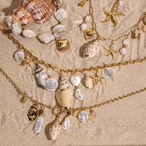 Titanium steel shell necklaces with pearls and starfish charms on a sunny beach background