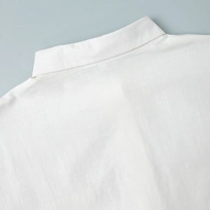 Gros plan du col de chemise en lin blanc montrant la texture du tissu et les coutures fines