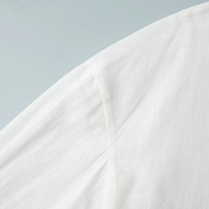 Macro de l'épaule d'une chemise blanche en coton et lin montrant les détails de couture