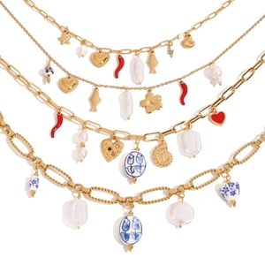 Detailed close-up of golden necklaces with baroque pearls and ocean-themed pendants