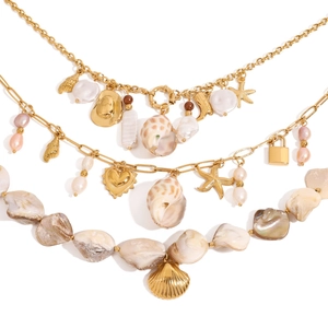 Detail of layered gold stainless steel necklace with baroque pearls and beach charms