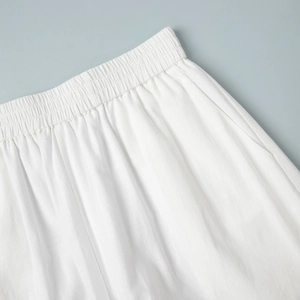 Détail de short blanc en coton et lin avec taille haute élastique et poches latérales