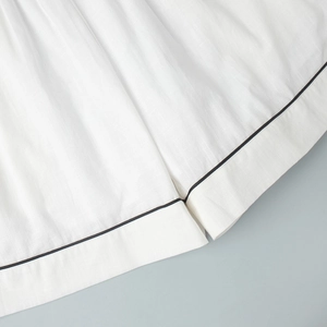 Macro d'un tissu en lin blanc de haute qualité avec passepoil noir et couture nette