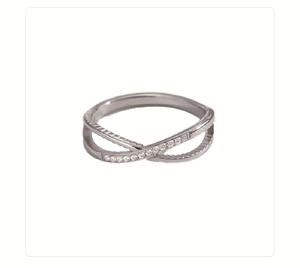 Macro detail of silver stainless steel cross ring featuring micro-pave crystal accents