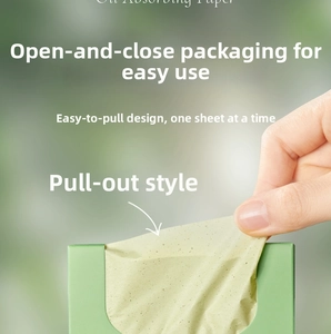 Macro shot of extracting a green oil-absorbing paper sheet from a portable dispenser box