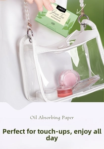 Green tea facial oil blotting paper shown inside a stylish transparent handbag