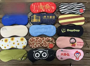 Various adjustable ice silk sleep masks with custom patterns on dark wooden background