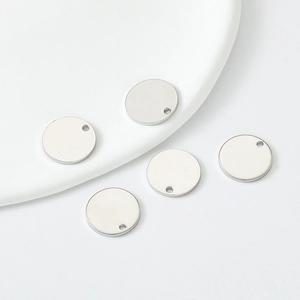 Macro detail of five polished silver round metal pendant charms for DIY jewelry making