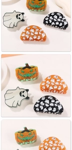 Detail of Halloween hair claws featuring pumpkin and luminous ghost glitter patterns