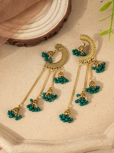 Detailed macro of vintage Indian Jhumka earrings with gold alloy and green beadwork