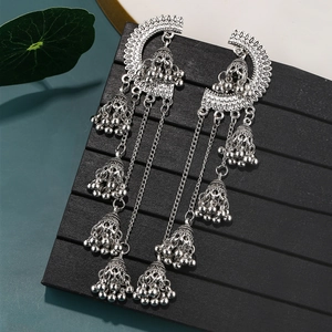 Macro detail of silver vintage tassel earrings with delicate hollow bells and fringe