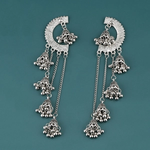 Close-up of vintage silver tassel earrings with delicate hollow bells and engraved details