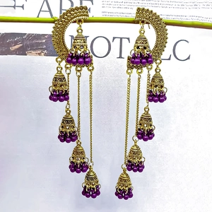 Detail of vintage gold Jhumka earrings with hollow fans and purple beaded bells
