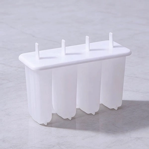 DIY 4-cavity popsicle mold in white plastic with lid and sticks on marble surface