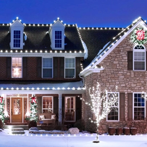 Solar LED copper wire fairy lights decorating a snowy outdoor house with warm white glow