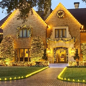 Panoramic night view of warm yellow solar copper wire lights decorating a garden villa