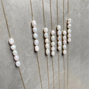 Detail of 18K gold plated necklaces featuring multiple baroque freshwater pearls on fine chains