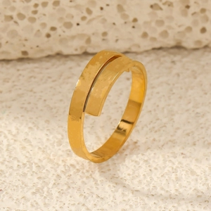 Detailed view of golden bypass ring with hammered metal texture on mineral display stand