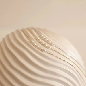 Detailed macro view of gold and silver plated chains with irregular freshwater pearls