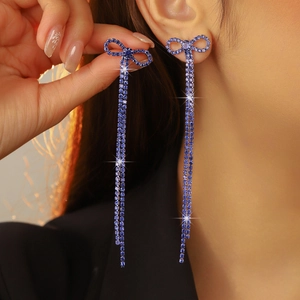 Close-up of blue rhinestone bow drop earrings on model for elegant wedding style
