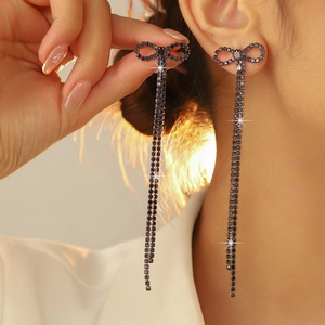 Detail of elegant black crystal bow earrings with long dangling tassel fringe