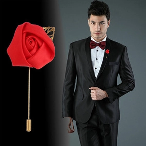 Detail of red fabric rose brooch with golden leaves on black suit lapel for men