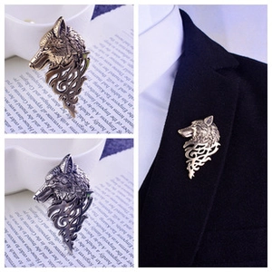 Detail of wolf head suit brooch with flame pattern on black blazer lapel and vintage props