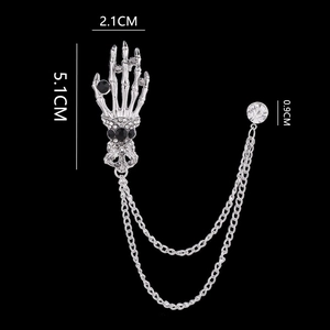 Detail of silver skull hand brooch with chains and rhinestones for men suit