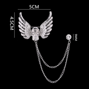 Detailed view of silver skull wings brooch with dual chains and size measurements