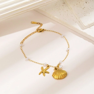 Pulsera de perlas barrocas doradas con dijes de estrella de mar y concha marina