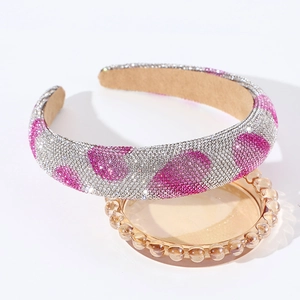 Detail of rhinestone headband with silver and pink crystal wave patterns on amber tray