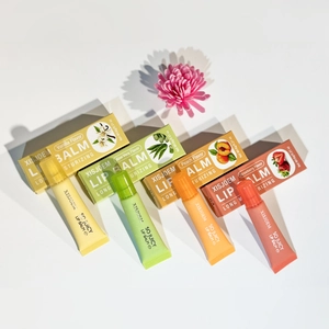 Flat lay of four hydrating lip balms in vanilla, aloe, peach and strawberry flavors
