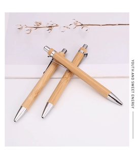Close-up of three eco-friendly bamboo ballpoint pens with silver metal clips and accents