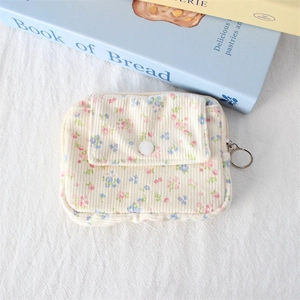 Detail of floral corduroy coin purse featuring a snap button pocket and zipper puller