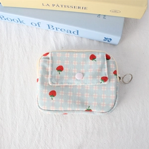 Detail of blue corduroy pouch with strawberry print and pink snap button pocket