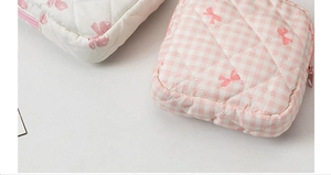 Dettaglio delle borse cosmetiche in cotone trapuntato con fiocchi rosa e motivi a quadretti