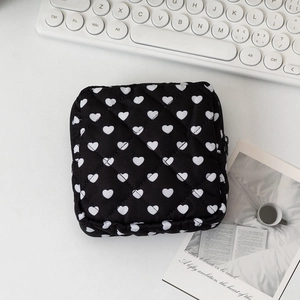 Dettaglio della trousse trapuntata nera con cuori bianchi e chiusura a zip robusta