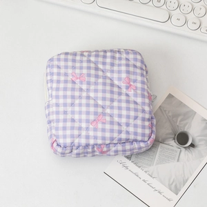 Dettaglio della pochette trapuntata a quadretti viola con fiocchi rosa e cerniera lampo