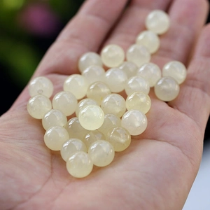 Macro detail of round milky white natural jade beads for DIY bracelet jewelry making