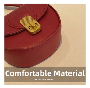 Detail showing the red leather saddle bag with a golden striped twist lock closure