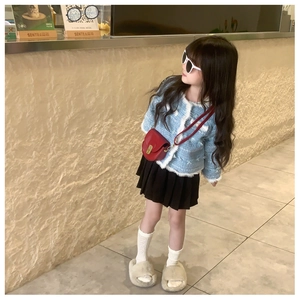 Girl's red leather saddle crossbody bag paired with light blue tweed jacket outfit