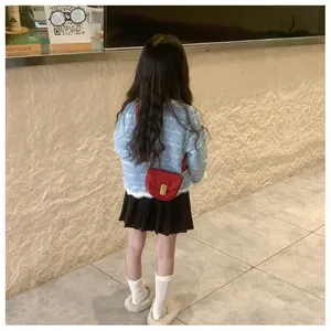 Rear view of a red semi-circular kids saddle bag paired with a blue tweed coat and skirt