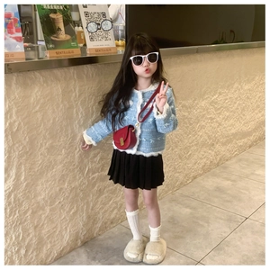 Girl's light blue tweed jacket and black pleated skirt outfit in a cafe setting