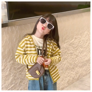 Girl's outfit featuring a yellow striped knit cardigan, white tee, and leather saddle bag