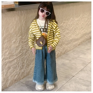 Close-up of a child's brown saddle bag paired with a yellow striped cardigan and jeans
