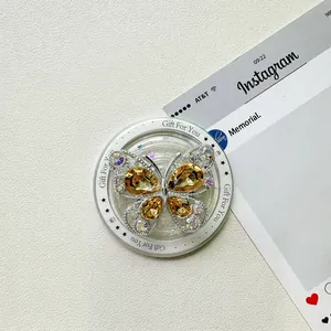 Détail du support téléphone papillon en strass avec cristaux ambrés et texte cadeau
