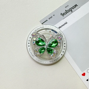 Gros plan du support de téléphone papillon avec gemmes vertes et strass brillants