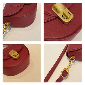Detail view of red leather saddle bag showing vintage gold buckle and fine stitching