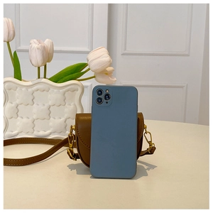 Brown leather saddle bag shown next to a smartphone for size reference and scale