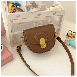 Detailed close-up of a brown matte leather kids saddle bag with a golden metal lock